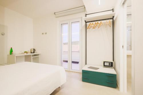 um quarto branco com uma cama e um espelho em Casa dei Venti - Guest House em Terracina