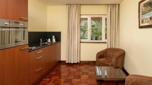 a kitchen with a glass table and a chair at Fairview Hotel Nairobi in Nairobi