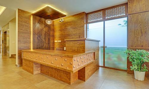 une grande salle de bains avec des murs en bois et une grande fenêtre. dans l'établissement Treebo Golden Terminal, Kochi Airport, à Cochin