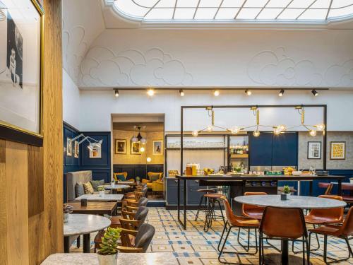 un restaurante con mesas y sillas y un bar en ibis Paris Grands Boulevards Opéra 9e, en París