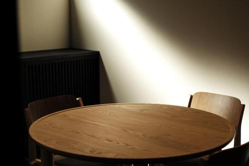 een houten tafel en 2 stoelen in een kamer bij SOUQ in Himeji