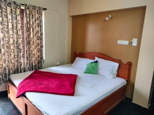 a bedroom with a bed with a red blanket on it at RAHUL STONE PALACE in Kodaikānāl