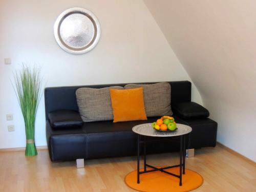 a black couch in a living room with a table at Appartement Föhrenvilla in Mödling