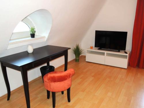 a room with a desk and a television and a chair at Appartement Föhrenvilla in Mödling