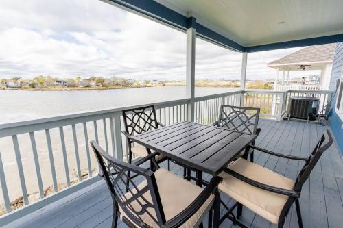 een tafel en stoelen op een veranda met water bij Water Front 3 25 Bath Kingbed Kemah Seabrook in Seabrook