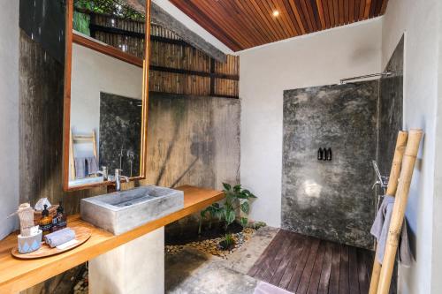 La salle de bains est pourvue d'un lavabo et d'une douche. dans l'établissement The Elementum, à Uluwatu