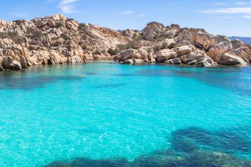 un grande corpo di acqua blu con rocce di Affittimoderni La Maddalena - MADA18 a La Maddalena