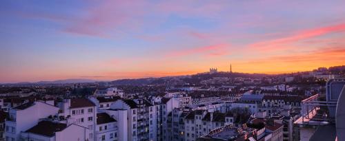 een uitzicht op de skyline van de stad bij zonsondergang bij PLEIN SUD Terrasse Panoramique Garage Netflix Climatisation in Lyon