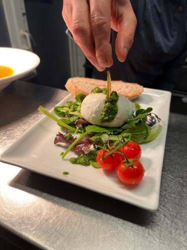 a person is preparing a salad on a plate at Hotel Hinrichs in Carolinensiel