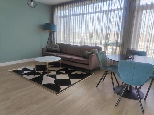 een woonkamer met een bank en een tafel bij K50163 Modern apartment near the center and free parking in Eindhoven