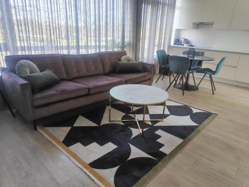 een woonkamer met een bank en een tafel bij K50163 Modern apartment near the center and free parking in Eindhoven