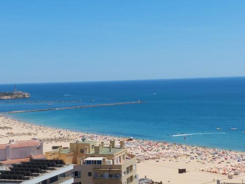 uma vista para uma praia com muita gente em Rocha T Apartments em Portimão