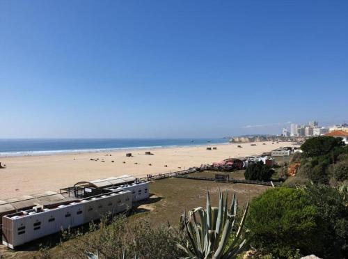 uma vista para uma praia com pessoas e para o oceano em Rocha T Apartments em Portimão