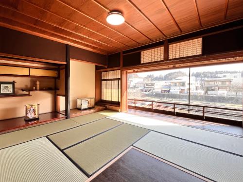 Zimmer mit einem großen Fenster und Yogamatten in der Unterkunft Hostel Miyagawa by Murasaki in Takayama