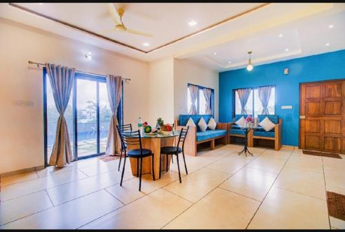 - un salon avec une table, des chaises et un canapé dans l'établissement OCEAN CREST LUXURY VILLA Mahabaleshwar, à Mahabaleshwar