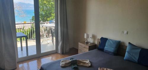 sypialnia z łóżkiem i dużym oknem w obiekcie Nafpaktos Beach House w mieście Nafpaktos