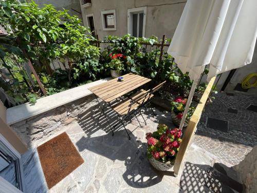 patio con ombrellone, panca e fiori di B&B Casa Limone a Limone sul Garda