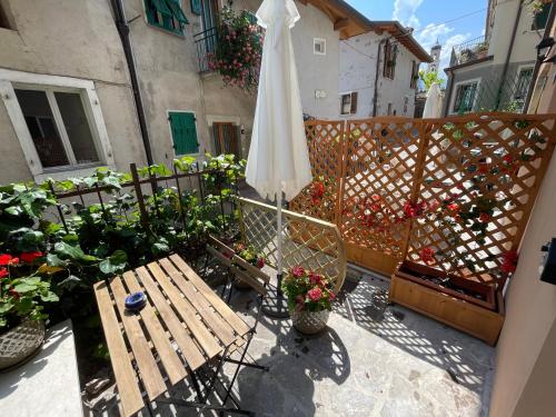 patio con tavolo, ombrellone e fiori di B&B Casa Limone a Limone sul Garda