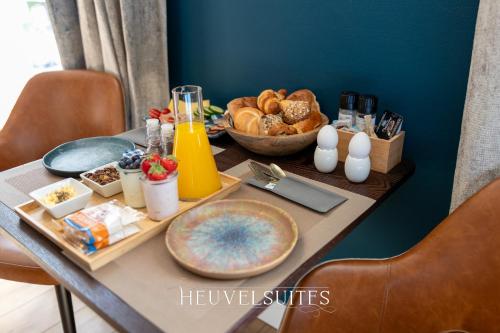 einen Tisch mit einem Tablett mit Essen und einer Schüssel Brot in der Unterkunft Heuvelsuites in Oosterhout