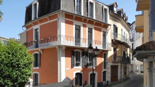 een oranje en wit gebouw met een balkon bij Villa Sérénité appartement au centre ville n 4 in Lourdes