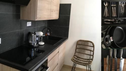 een keuken met een zwart aanrecht en een stoel bij Villa Sérénité appartement au centre ville n 4 in Lourdes