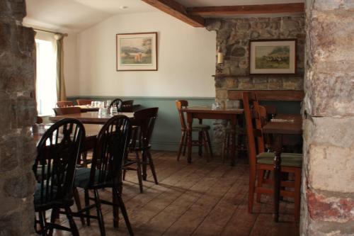 ein Esszimmer mit Holztischen und -stühlen in der Unterkunft Farmers Arms in Taunton