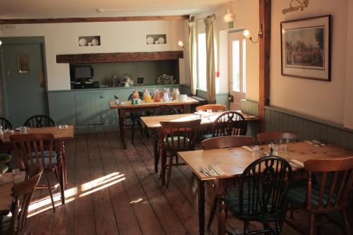 ein Restaurant mit Holztischen und -stühlen in einem Zimmer in der Unterkunft Farmers Arms in Taunton