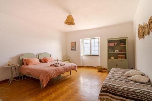 1 dormitorio con 2 camas y mesa. en Manas Coliving, en Sines