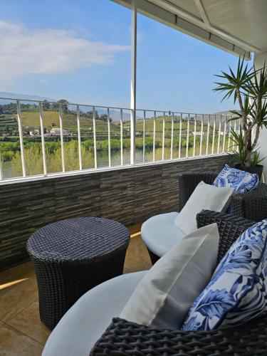 a balcony with chairs and tables and a view at Vistadouro in Peso da Régua