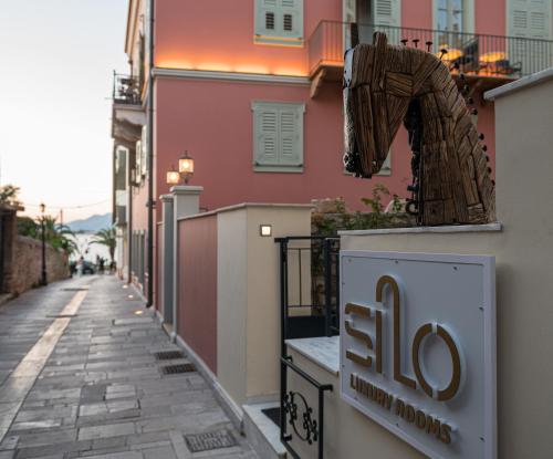 un panneau sur le côté d'un bâtiment dans une rue dans l'établissement Silo Luxury Rooms, à Nauplie