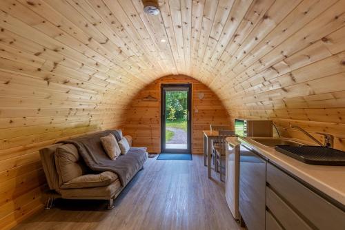 - un salon avec un canapé dans une cabane en rondins dans l'établissement Mount Hillary Holiday Pods, à Cork