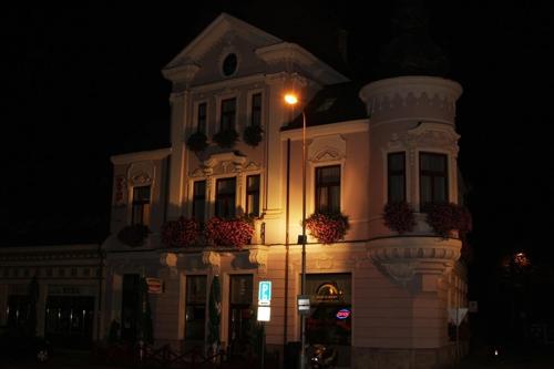 a white building with a street light in front of it at Olymp penzion in Komárno