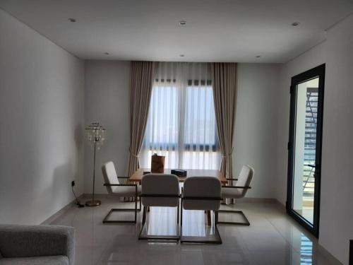 sala de estar con mesa de comedor y sillas en Beachfront 2BHK apartment at Al Mouj, en Seeb