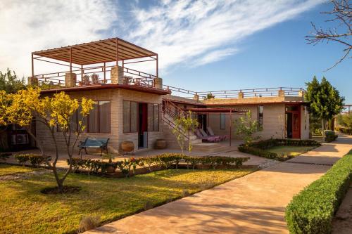 une maison avec un balcon au-dessus dans l'établissement La Ferme de LallaDom, à Tameslouht