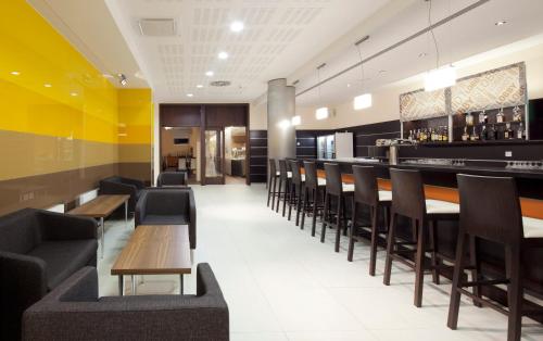 a restaurant with chairs and tables and a bar at Clarion Congress Hotel Ostrava in Ostrava