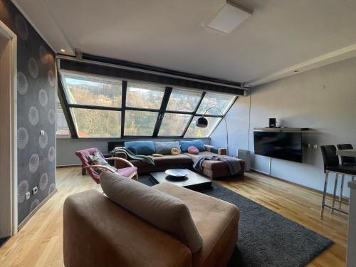 a living room with a couch and a large window at Amazing Penthouse old town in Sarajevo