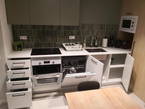 a kitchen with white counters and a stove top oven at Apartamento céntrico Sitges, cerca de todo andando in Sitges