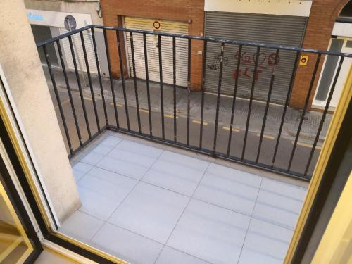 a balcony with a gate and a tile floor at Apartamento céntrico Sitges, cerca de todo andando in Sitges