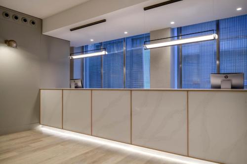 an office with a reception desk and large windows at AC Hotel Carlton Madrid by Marriott in Madrid