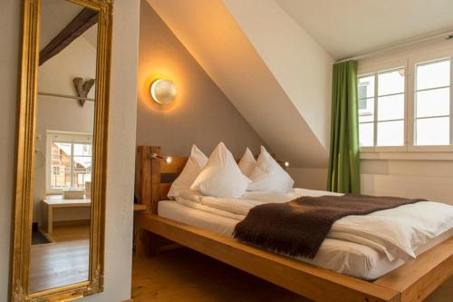 a bedroom with a bed with a large mirror at Boutique Hotel The River House in Andermatt