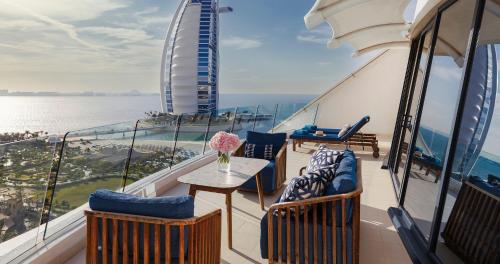 einen Balkon mit Stühlen und einem Tisch auf einem Kreuzfahrtschiff in der Unterkunft Jumeirah Beach Hotel Dubai in Dubai