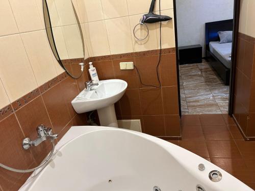 a bathroom with a tub and a sink and a mirror at Mini Hotel Smak in Dnipro