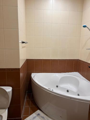 a bathroom with a tub and a toilet at Mini Hotel Smak in Dnipro