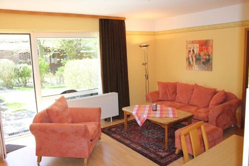 een woonkamer met een bank, stoelen en een tafel bij Apartmenthaus Padua in Büsum