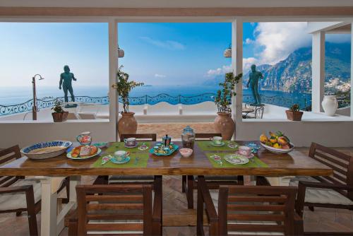 uma sala de jantar com uma mesa e vista para o oceano em Villa Santa Chiara Positano Suites em Positano