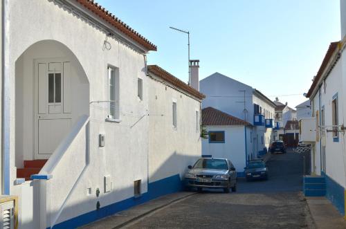 een auto geparkeerd in een steegje tussen twee gebouwen bij Casa do Viajante - Family in Zambujeira do Mar