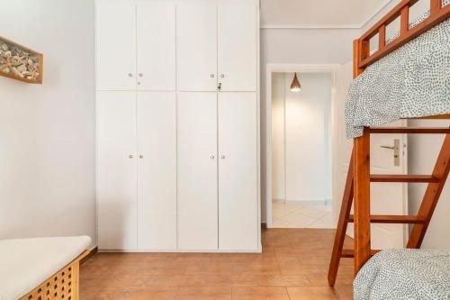 een slaapkamer met witte kasten en een stapelbed bij Modern Apartmen, Piraeus near Microlimano, Kastela in Piraeus