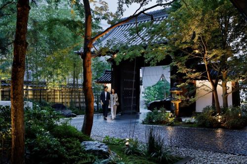 un homme et une femme se promènent dans un bâtiment dans l'établissement HOTEL THE MITSUI KYOTO, a Luxury Collection Hotel & Spa, à Kyoto