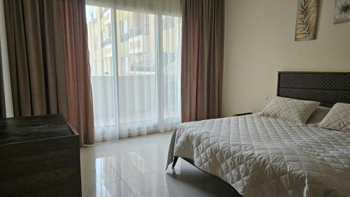 um quarto com uma cama e uma grande janela em Unique 2bd apt Marjan Island em Ras al-Khaimah