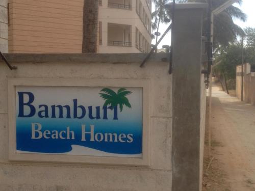 um sinal para uma casa de praia numa parede em Bamburi Beach Homes em Bamburi